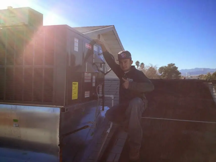 HVAC technician performing AC Tune-Up on a rooftop unit in Eagle Pass